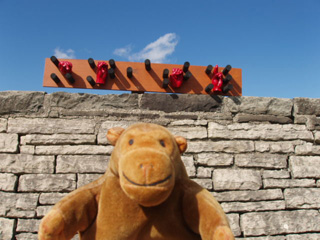 Mr Monkey in front of a braille and sign language artwork on a rampart