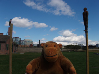 Mr Monkey between a bird on a pole and a child-bear on a pole