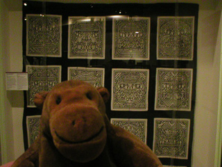 Mr Monkey in front of a Chinese quilt cover