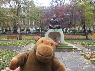 Mr Monkey in front of a statue of Gandhi