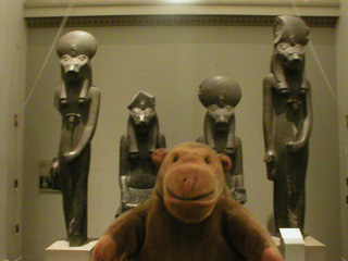 Mr Monkey in front of four statues of Sukhmet