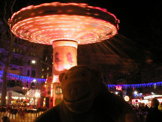 Mr Monkey in front of a spinning chair-o-plane ride