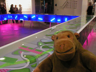 Mr Monkey beside a bright blue and green model