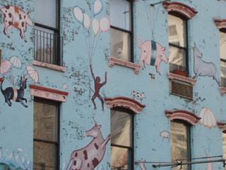Balloon borne animals painted above a row of shops