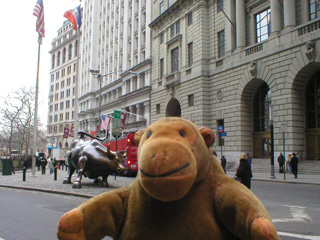 Mr Monkey looking across the street at a statue of a bull
