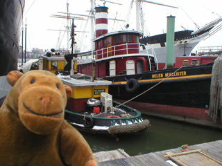Mr Monkey in front of a pair of tugs