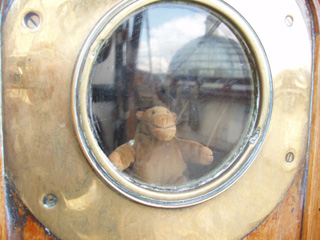 A porthole with Mr Monkey looking out