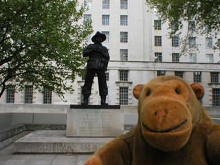 Mr Monkey in front of a statue of General Slim