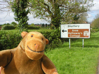 Mr Monkey looking at a sign for Anne Hathaway's Cottage