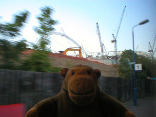 Mr Monkey approaching a half-built football stadium