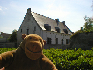 Mr Monkey looking at the farmhouse from behind a hedge on the other side of the road