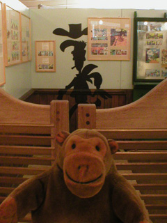 Mr Monkey outside a saloon, with Lucky Luke's shadow behind him