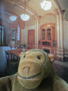 Mr Monkey in front of a picture of Horta's dining room