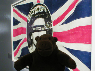 Mr Monkey in front of a God Save the Queen poster