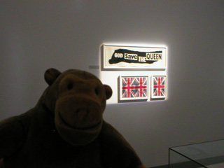 Mr Monkey looking at artwork for God Save the Queen posters