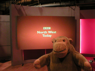 Mr Monkey in front of a screen saying North West Today