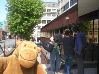 Mr Monkey watching a sound crew doing something outside the BBC