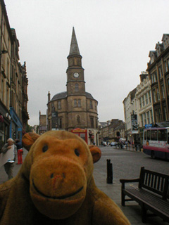 Mr Monkey walking along a street in Stirling