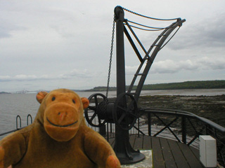 Mr Monkey examining a crane on a pier