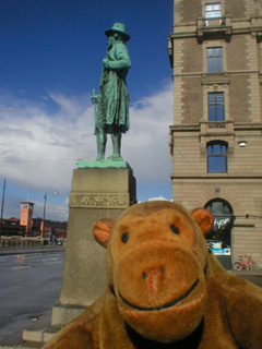 Mr Monkey below a statue of Frans Suell