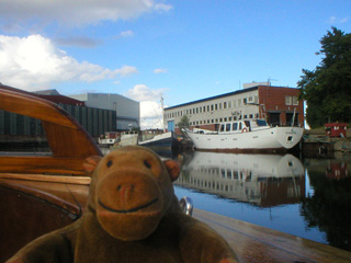 Mr Monkey passing a row of boats under repair