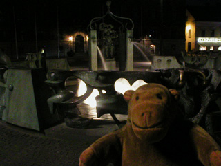 Mr Monkey in front of the Stortorget fountain at night