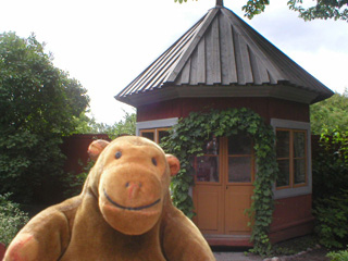 Mr Monkey in front of a vicar's summerhouse
