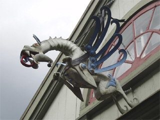 A pouncing metal dragon above a doorway