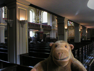 Mr Monkey looking at the pews inside St Giles church