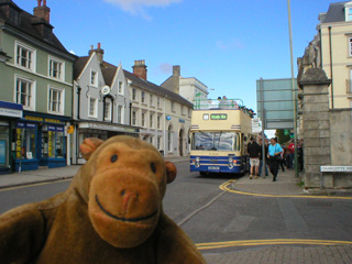 Mr Monkey looking at an open top bus from a distance