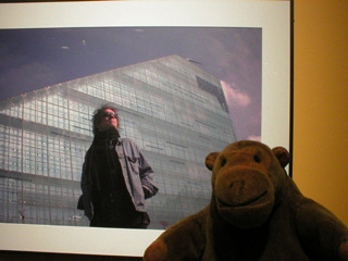 Mr Monkey with a picture of Mick Rock outside Urbis