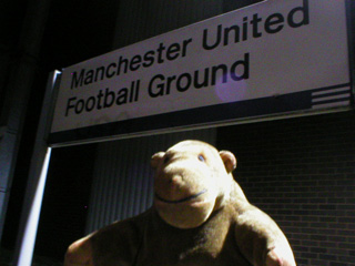 Mr Monkey beneath the sign for Manchester United Football Ground
