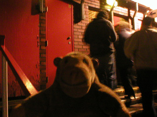 Mr Monkey watching people go through the narrow doors from the station