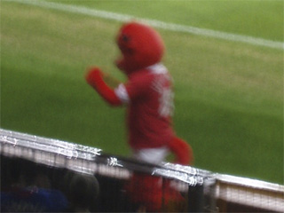 The Red Devil mascot running along the sidelines