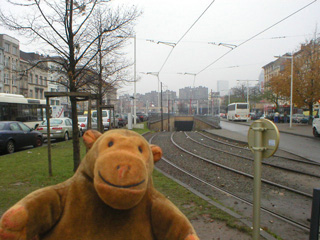 Mr Monkey looking at tramlines going into an underground tunnel