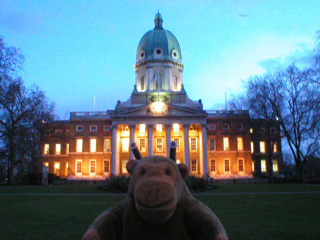 Mr Monkey outside the Imperial War Museum in the dark