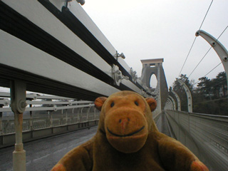 Mr Monkey walking across the Clifton Suspension bridge