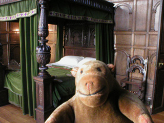 Mr Monkey examining the four poster bed in the bedroom