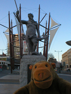 Mr Monkey looking at a statue of Neptune