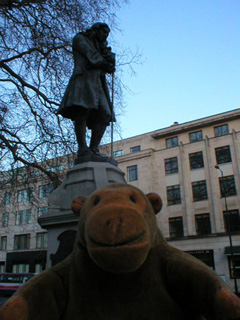 Mr Monkey looking at the statue of Edward Colston