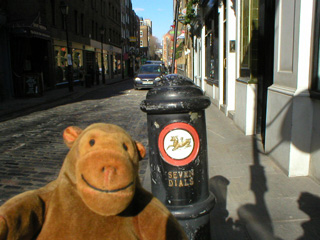 Mr Monkey looking at a Seven Dials street bollard