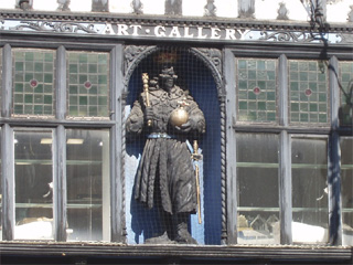 A carved figure on the front of a building in the Rows
