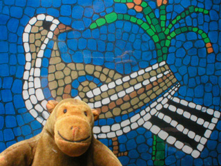 Mr Monkey in front of a picture of some real mosaic