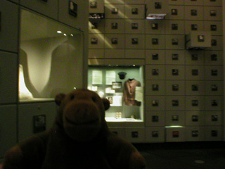 Mr Monkey looking at a wall of filing cabinet drawers in Silo 1