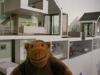 Mr Monkey looking at a model of an experimental house