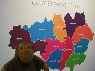 Mr Monkey looking at a schematic of Greater Manchester