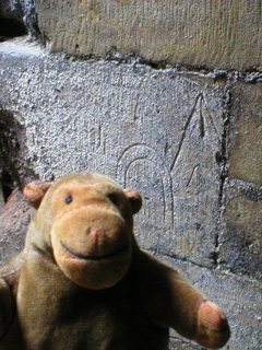 Mr Monkey looking at mason's marks beside the cellar steps