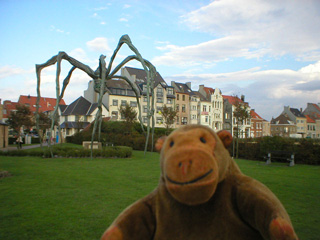 Mr Monkey looking at Maman with a row of houses in the background
