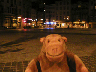Mr Monkey crossing a square after dark
