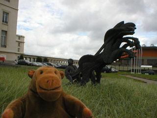 Mr Monkey looking at a sculpture of a chariot